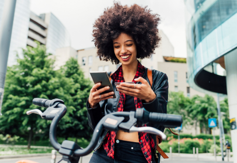 Chica con celular en bicicleta - Seguro de celulares Itaú