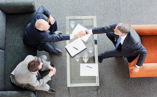 Cliente en reunión con otros y firmando un contrato